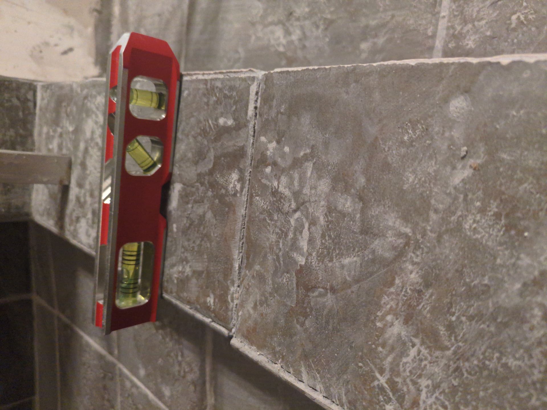 Using a spirit level to ensure a flat subfloor for tile installation